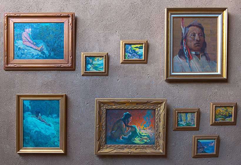 Couse’s paintings hanging on his studio wall.